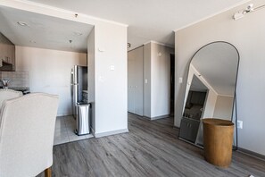 Une cuisine moderne dotée d’un four encastré, d’un réfrigérateur en acier inoxydable et d’un plancher en bois.