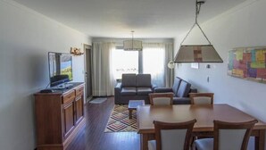 Un espacio habitable compacto con comedor, sofá y televisor.