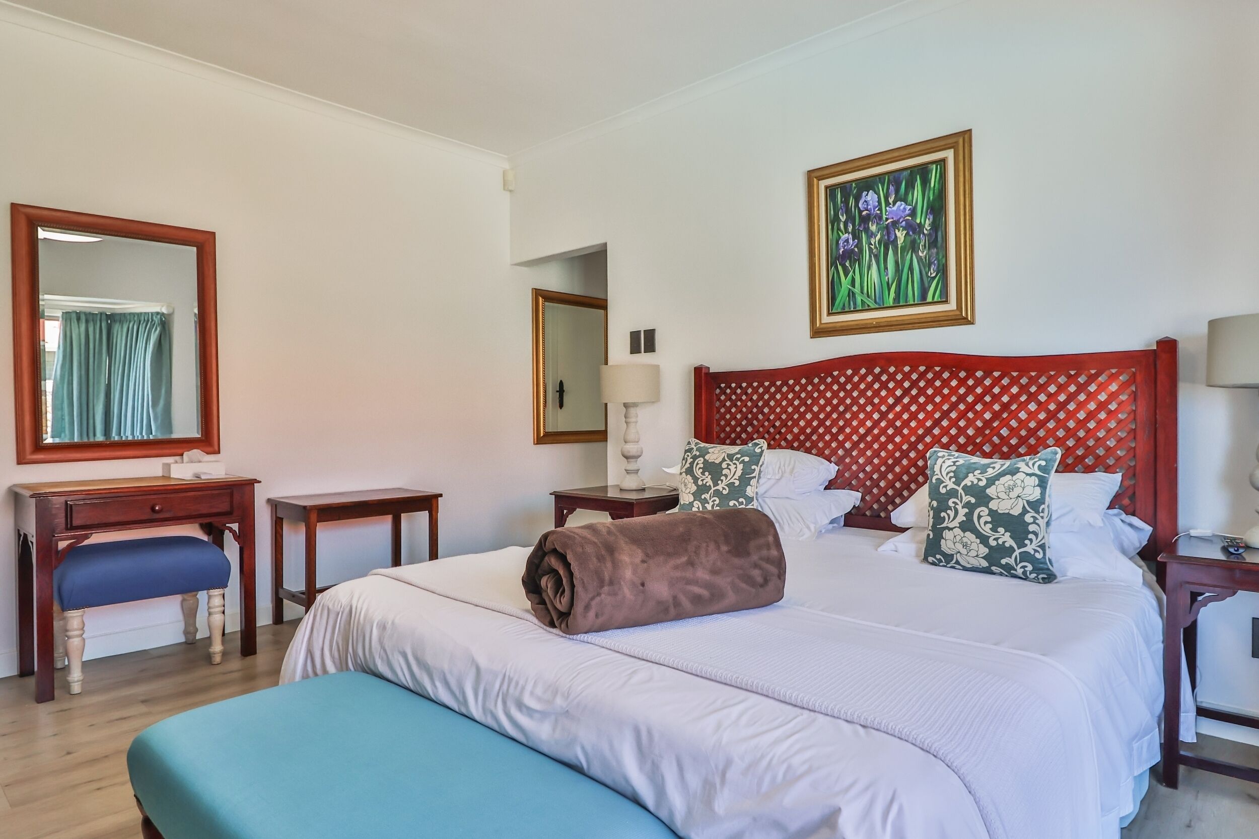 Ein Hotelzimmer mit einem großen Bett, einem Schreibtisch, einem Stuhl und einem Spiegel.