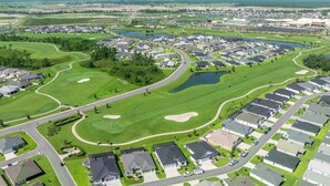 Vista aérea de un campo de golf con viviendas residenciales a su alrededor.