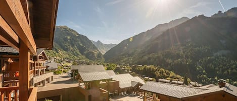 Un complejo turístico de montaña con edificios de madera, un patio y vistas a las montañas circundantes.