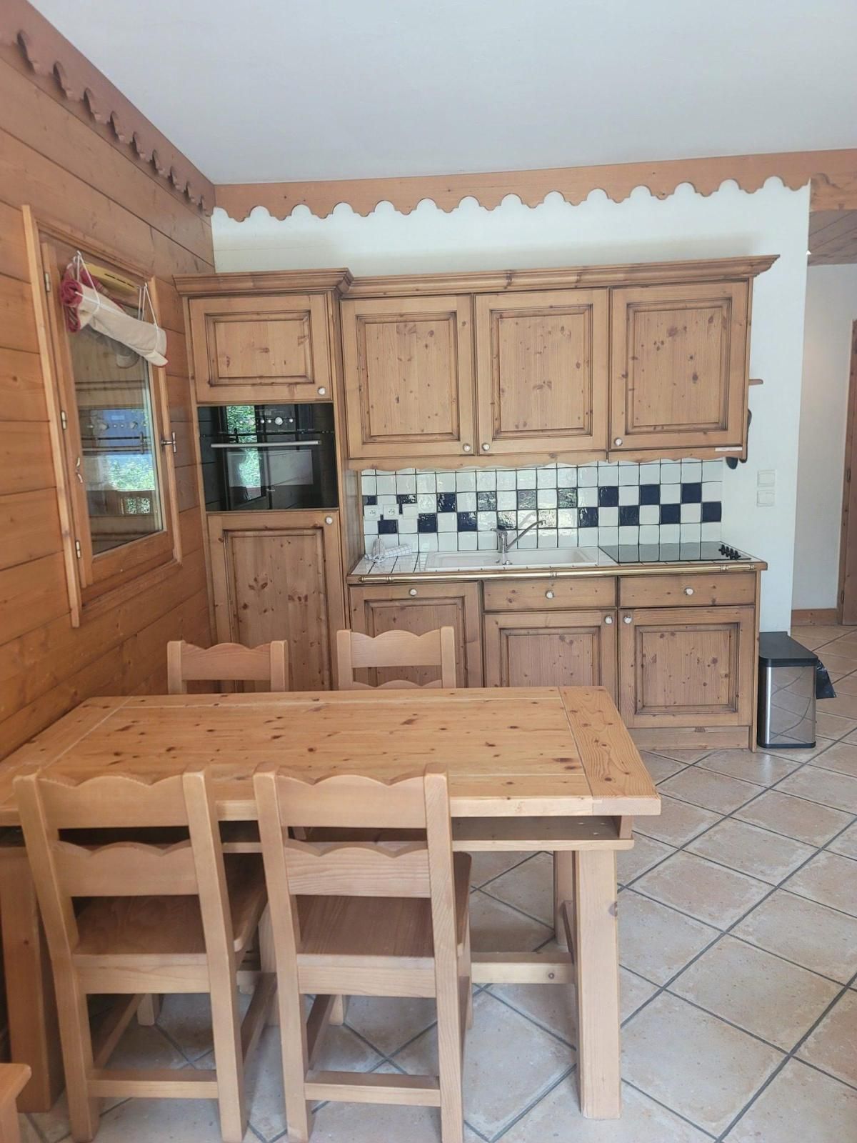 A wooden kitchen with a tiled backsplash, a stove, and cabinets.