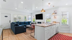 A modern kitchen with white cabinetry, a central island, and pendant lighting. - San Diego Gem-Charming 4BR Home (San Diego)