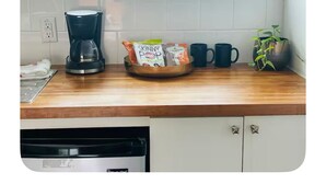 A kitchen with a coffee maker, a bowl of snacks, and a potted plant. - Vintage Chalet Studio 6 Creative Walkable Montrose H-Town Favorite!! (Houston)
