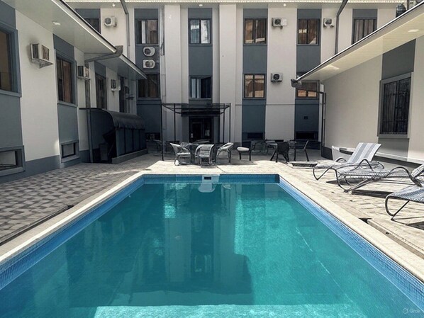 Piscine extérieure, parasols de plage, chaises longues