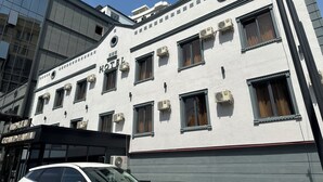 A hotel with a classic facade, multiple air conditioning units, and a prominent "HOTEL GRAND ZAMIN" sign. - Grand Zamin Hotel (Tashkent)