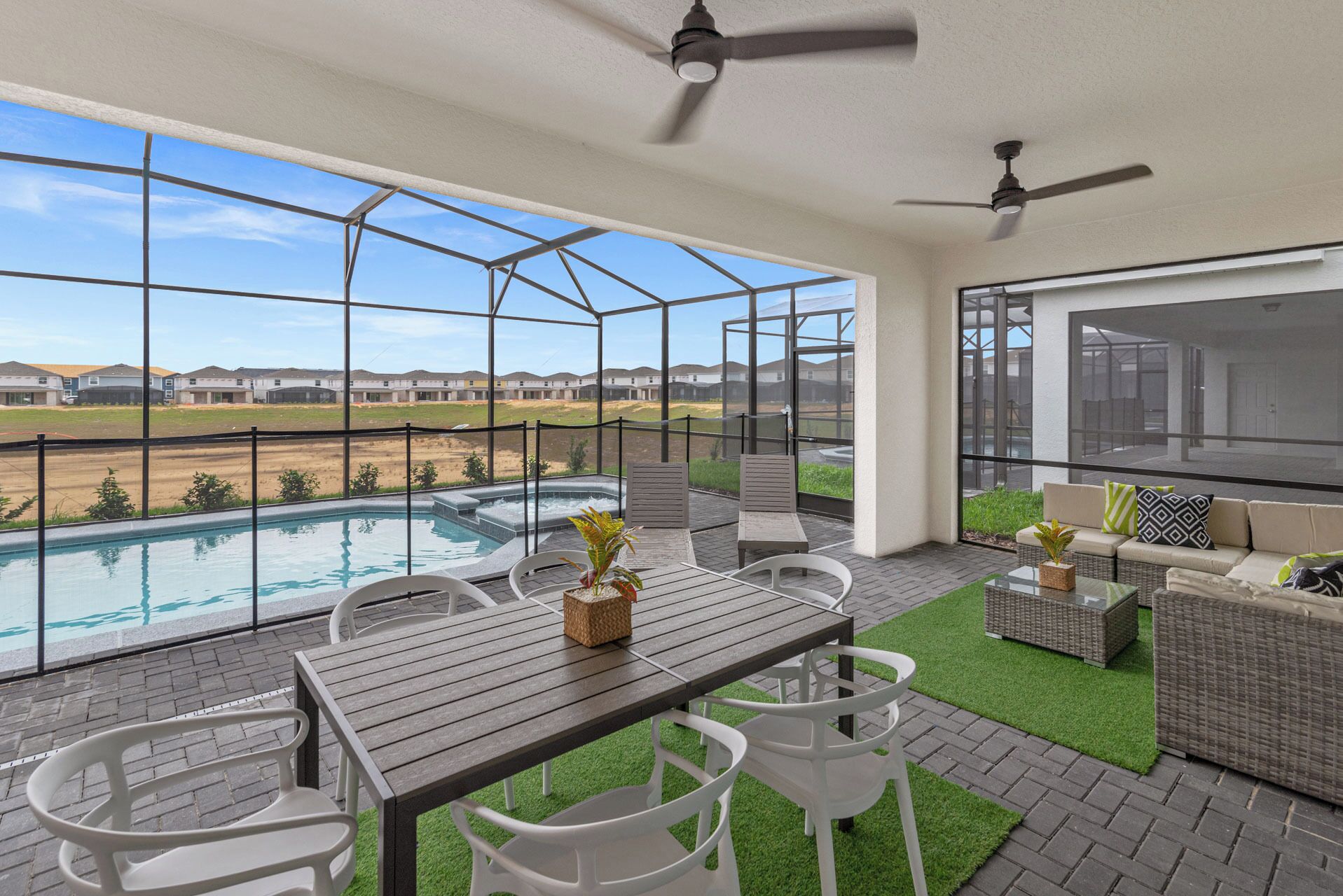 Un balcon avec une piscine, un espace salon extérieur et une vue sur un quartier résidentiel.