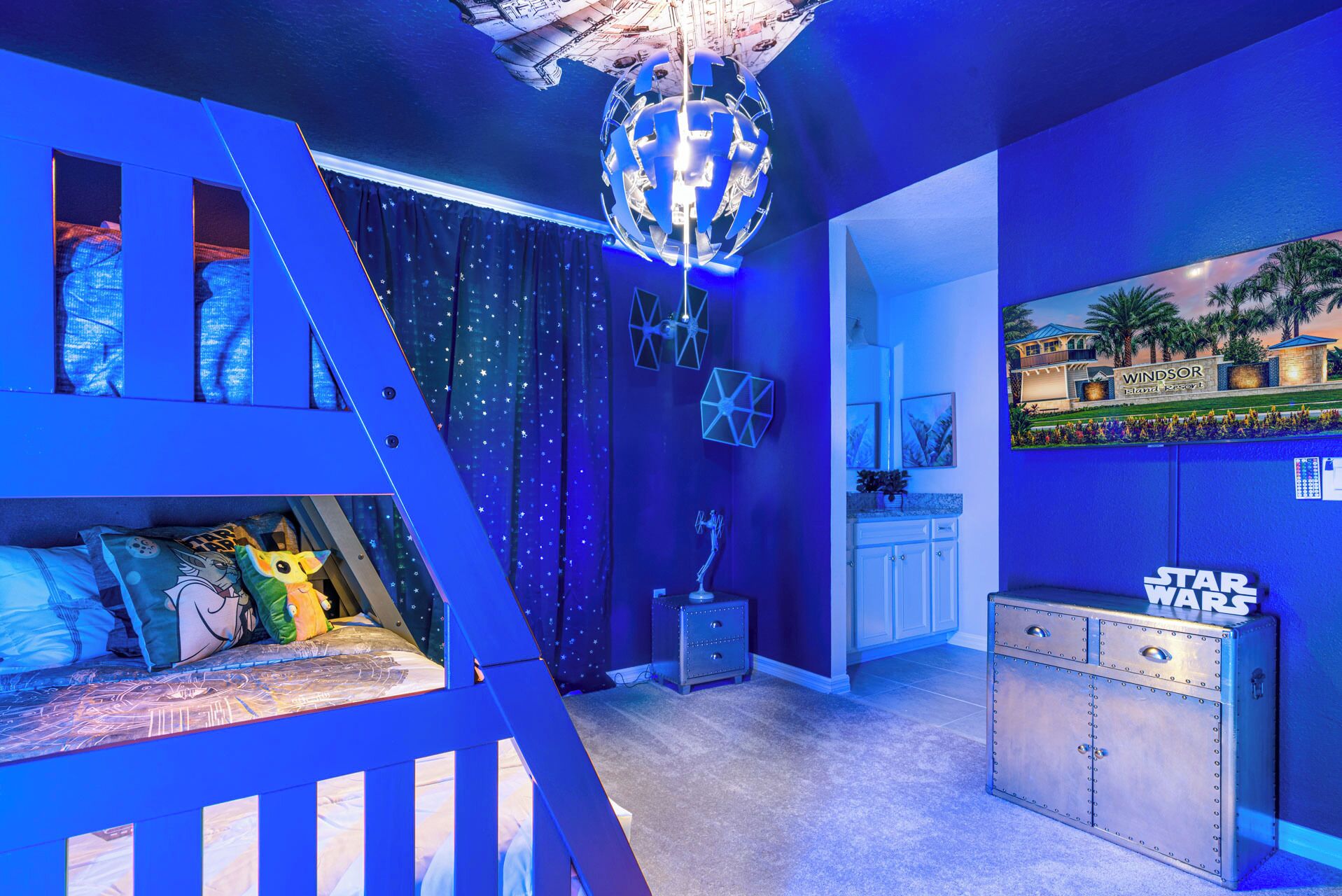 A Star Wars-themed room with a bunk bed, a globe light, and a wall-mounted cabinet.