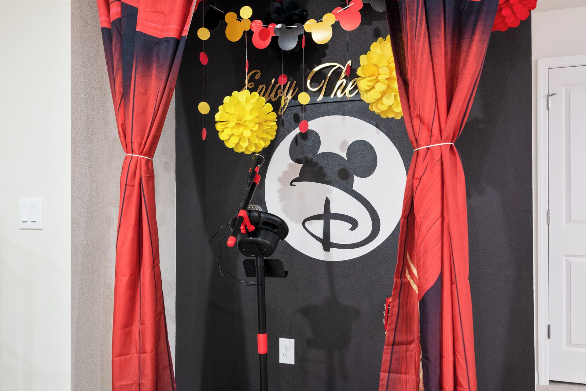 Een gordijn met een Mickey Mouse silhouet en een dollarsymbool, met de tekst 'Happy The' op een zwarte achtergrond.