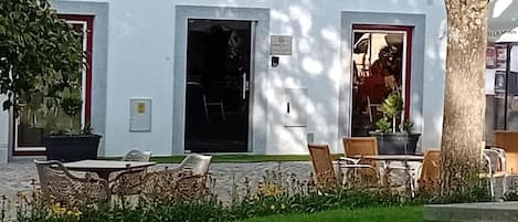 A building labeled 'Garden House Fundão' with outdoor seating and a tree.