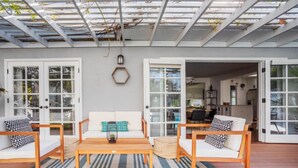A spacious living area with a wooden coffee table, two white sofas with patterned cushions, and a blue-striped rug. - Adorable 3 bdr Home Universal Pool hot tub (Los Angeles)