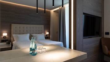 Una habitación de hotel moderna con una cama grande, mesitas de noche con lámparas, un escritorio con silla y una ventana.
