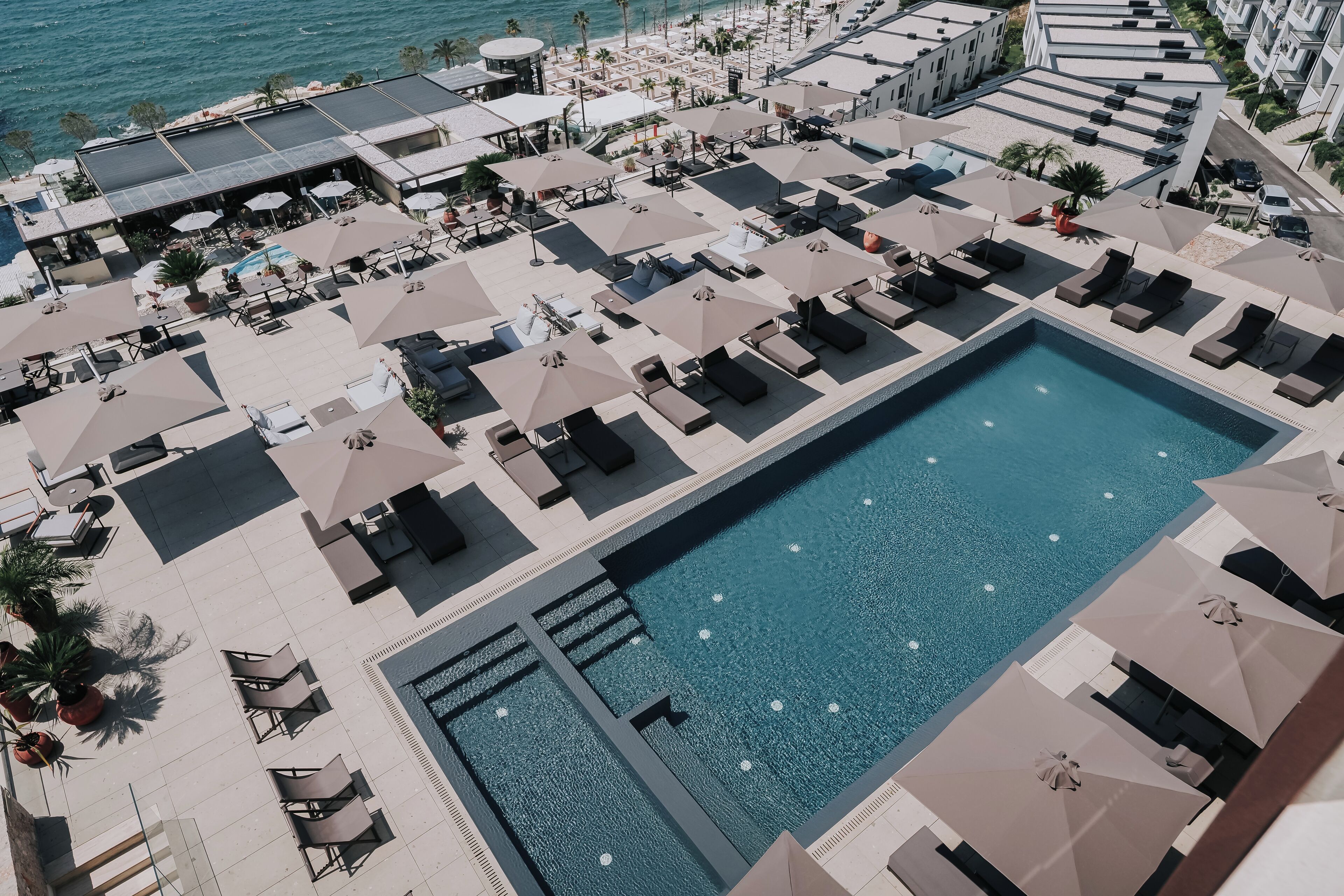 Una piscina al aire libre de temporada, sombrillas