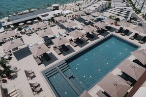 Una piscina al aire libre de temporada, sombrillas