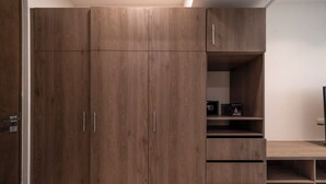 A large wooden wardrobe with multiple compartments and a built-in shelf unit.