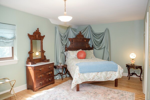 A bedroom with a wooden bed, a dresser, a mirror, and a nightstand. - Marvelous lakefront 4-bedroom historical estate in Richfield with AC. (Richfield)