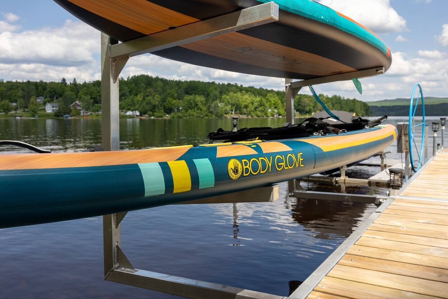 Un kayak de la marque « BODY GLOVE » est amarré à un quai au bord d’un lac.