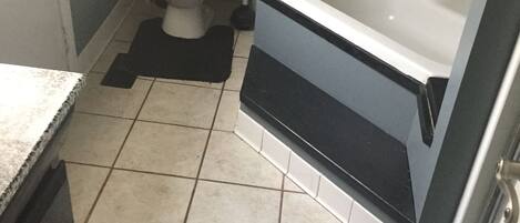 A bathroom with a toilet, sink, and bathtub.