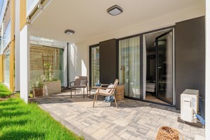 An outdoor patio with a seating area, a small table, and a basket. - Apartamenty Morskie - SPA - Posesja Plażowa Grzybowo by POSESJA APARTAMENTY (Grzybowo)