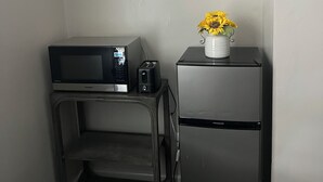 Una kitchenette equipada con microondas, tostadora y refrigerador.