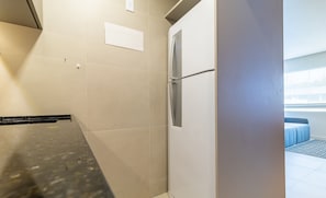 Casa de banho moderna com chuveiro, sanita e lavatório. Uma porta dá acesso a uma varanda com vista.