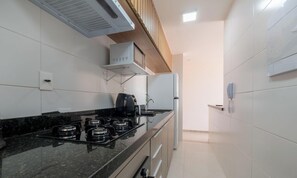 A kitchen with a gas stove, microwave, and a coffee maker.