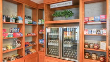 Una despensa del Greystone Lodge con estantes llenos de aperitivos, bebidas y artículos de aseo.