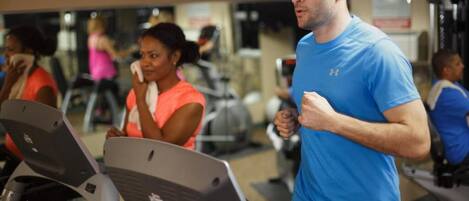 Et fitnesscenter med løbebånd og træningsudstyr.