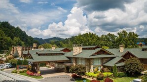 A lodge with a stone facade, multiple roof styles, and a covered entrance.