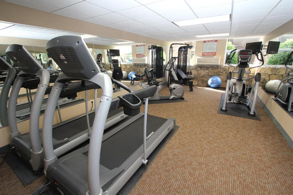 A gym with treadmills, elliptical machines, and weight equipment.