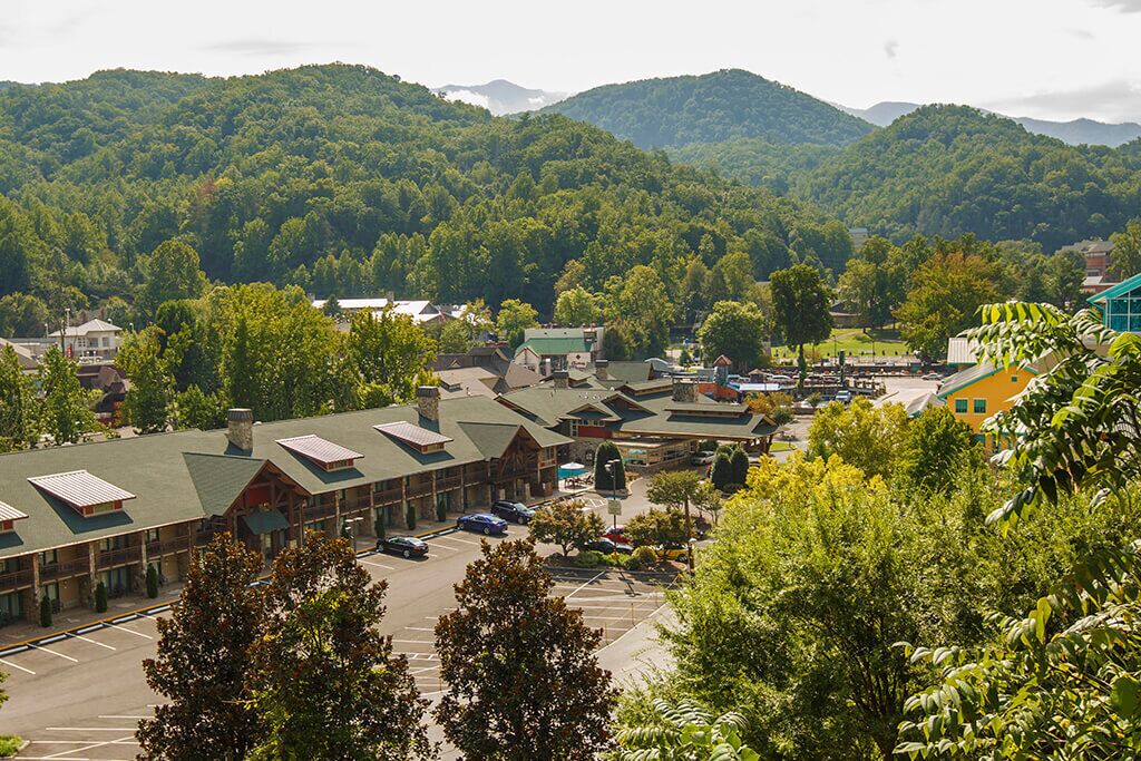 A lodge with multiple buildings, a parking lot, and a mountainous backdrop.