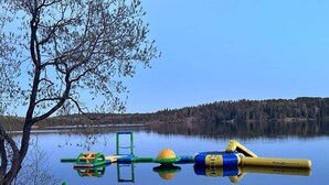 En lugn sjö med uppblåsbara leksaker och ett träd som speglas i vattnet.