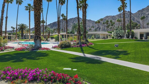 A resort with a swimming pool, palm trees, and a mountain backdrop. - GATED, Spacious 2-bedroom condo in Indian Wells close to restaurants and more. (Indian Wells)