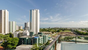 Un edificio de gran altura con varios pisos, rodeado de otros edificios y zonas verdes.