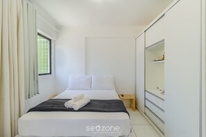 A bedroom with a bed, a bedside table, a mirror, and a window with curtains. - Near the sea and the Best of Recife! Cav0411 (Recife)
