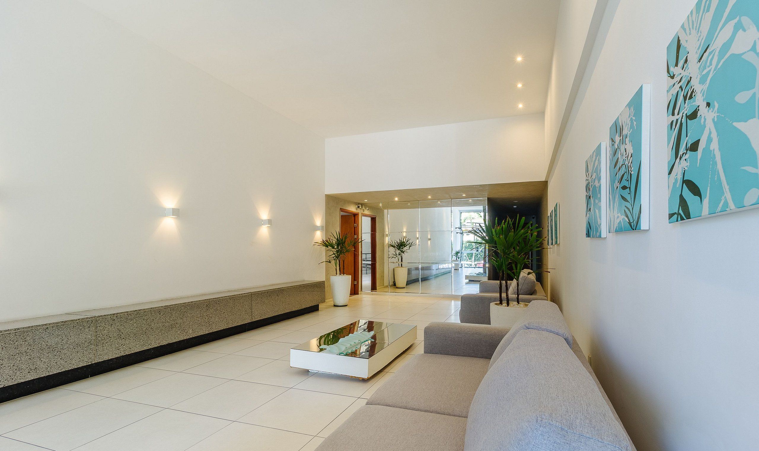 A modern lobby with a sofa, a coffee table, and wall art.