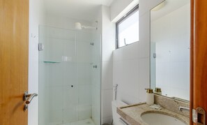 A bathroom with a glass shower enclosure, a sink with a granite countertop, and a large mirror. - Near the sea and the Best of Recife! Cav0411 (Recife)