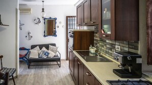 A compact kitchen with dark wooden cabinets, a built-in stove, and a sink. - House in the mountains near the sea (Itala)