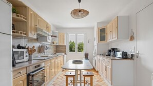 Une cuisine moderne avec des meubles en bois, un îlot central et une grande fenêtre.