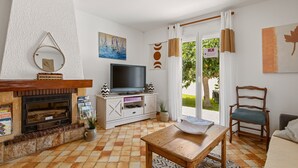Un salon avec une cheminée, un téléviseur et un coin repas.