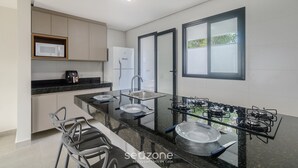 A modern kitchen with a black countertop, stainless steel appliances, and a window with a view. - Apartments With Swimming Pool 700m From Taperapuan Beach Nvm0009 (Porto Seguro)