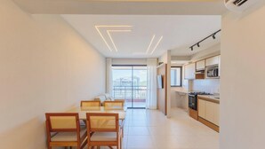 A modern kitchen with white cabinets, a microwave, and a stove. - Beachfront Building With Pool - CPK (Ilhéus)