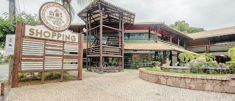A shopping area with a signboard listing various shops and services.