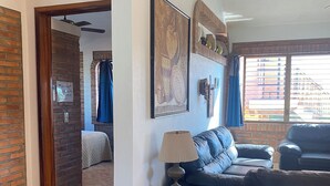 A living room with a sofa, a lamp, and a painting on the wall. - Casitas Las Palmas (Punta de Mita)