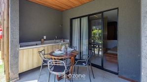 Una cocina moderna con encimera de madera, una mesa de comedor con sillas y un ventanal corredero que da a un balcón.