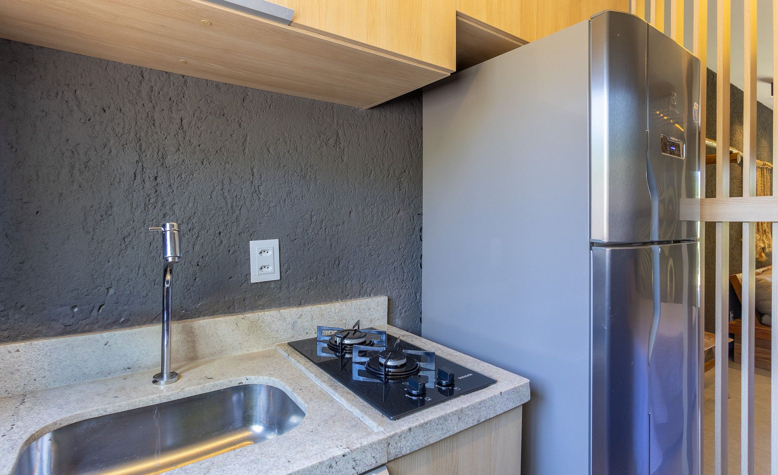 Una cocina con un refrigerador de acero inoxidable, un lavamanos doble y una estufa a gas.