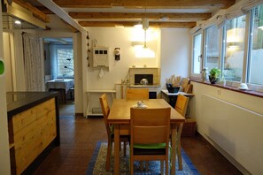 Una cocina acogedora con muebles de madera, una mesa de comedor y una ventana con vistas.
