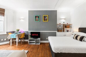 Tabla de planchar con plancha, internet y ropa de cama