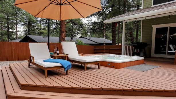 A wooden deck with two lounge chairs and a hot tub. - Forest Retreat at Canyon Loop (Flagstaff)