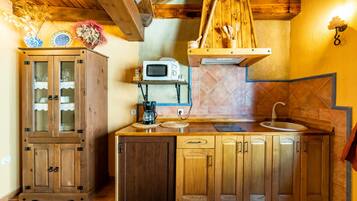 Una cocina con armarios de madera, microondas y un colgador para ollas.
